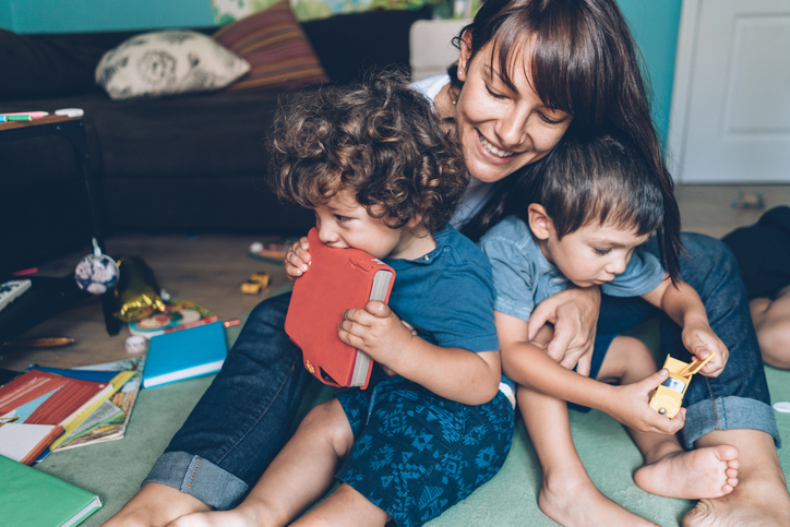 Moth and two sons sitting on living room floor